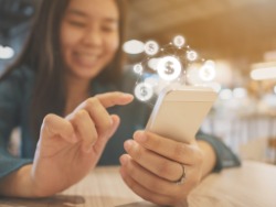 A woman uses her cellphone to pay for bills.