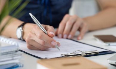 A woman signs a document.