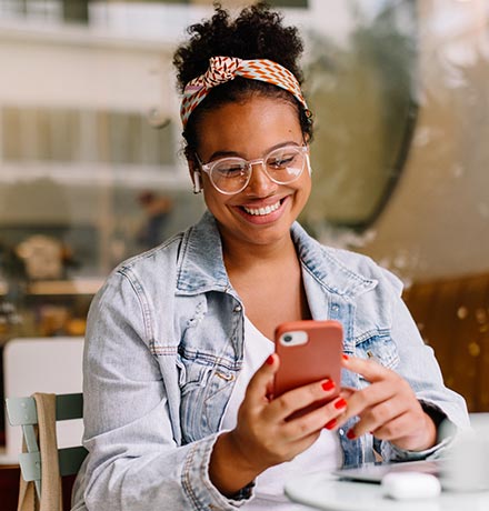 Woman looking at phone at a cafe.