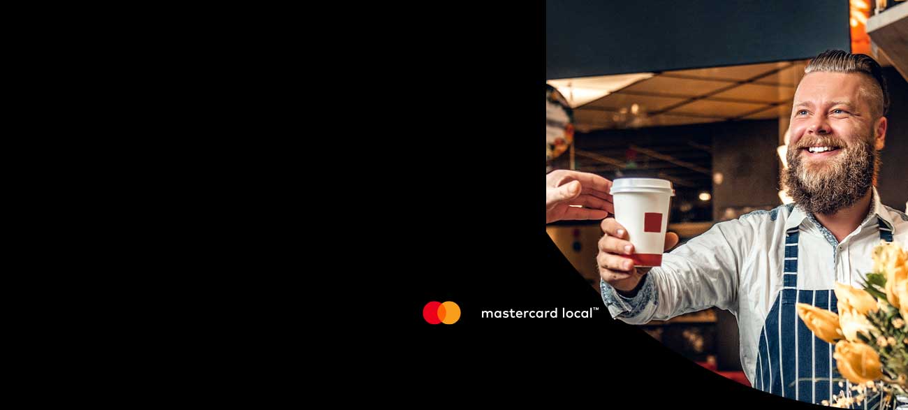 A man hands over a coffee to a customer.