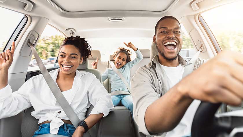 Family smiling in a car.