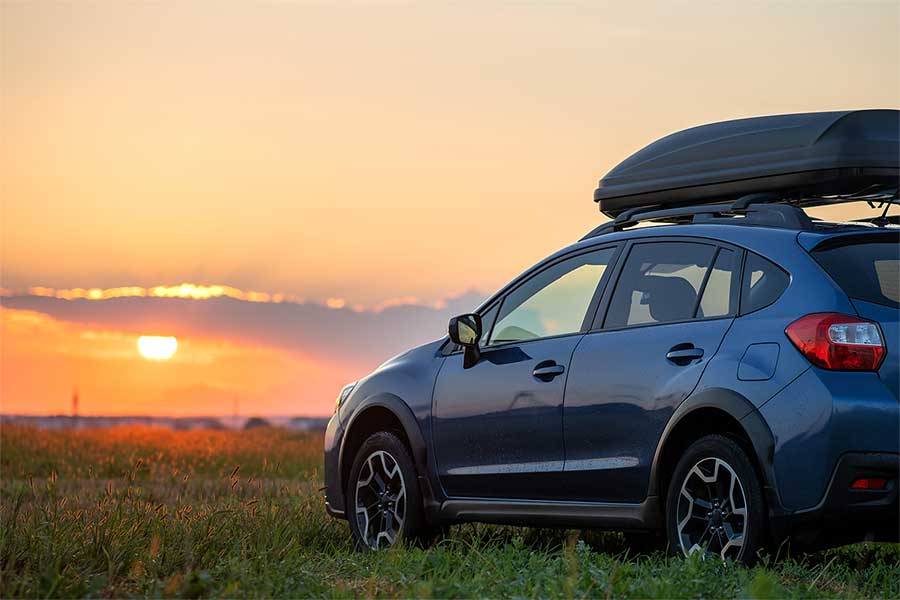 A car parked on the grass during sunset.
