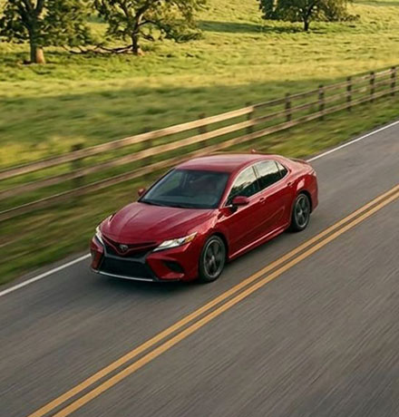 Red car driving down the road.