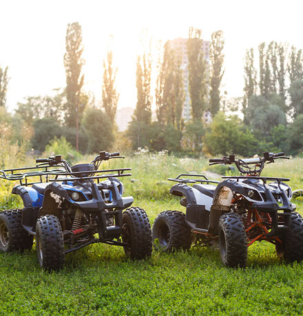 Two ATVs next to each other in a field.