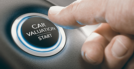 A man uses his thumb to push a car start button.