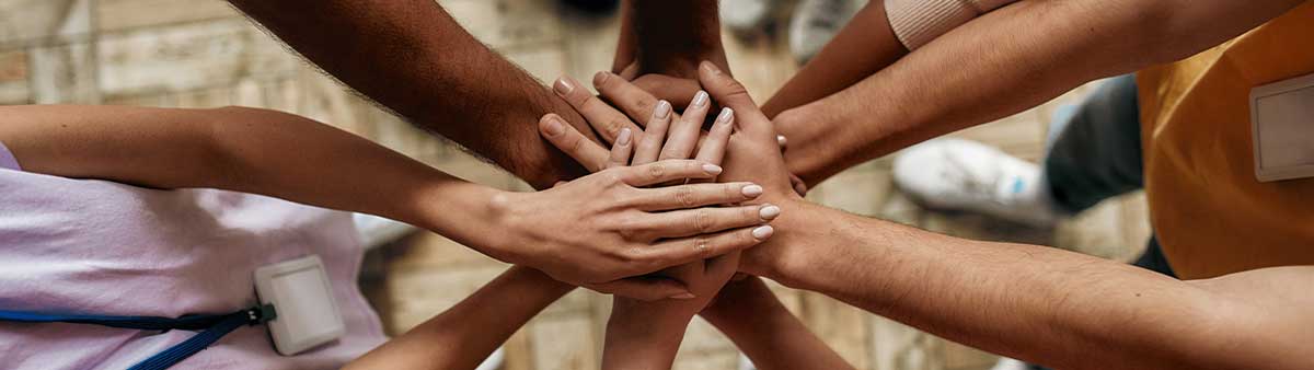 A diverse group of people holding hands. 