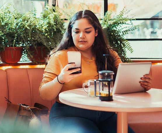 Woman using a phone and tablet.