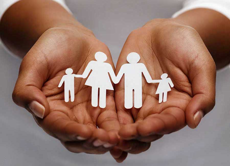 A woman open hands holding a paper cut out of a family. 