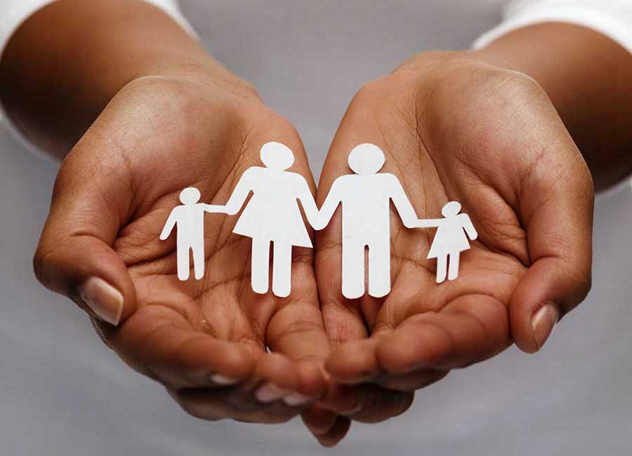 A woman open hands holding a paper cut out of a family.