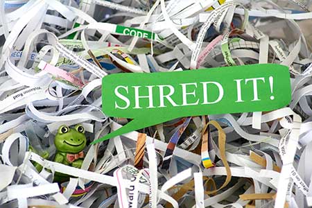 A toy frog in a shred bin.