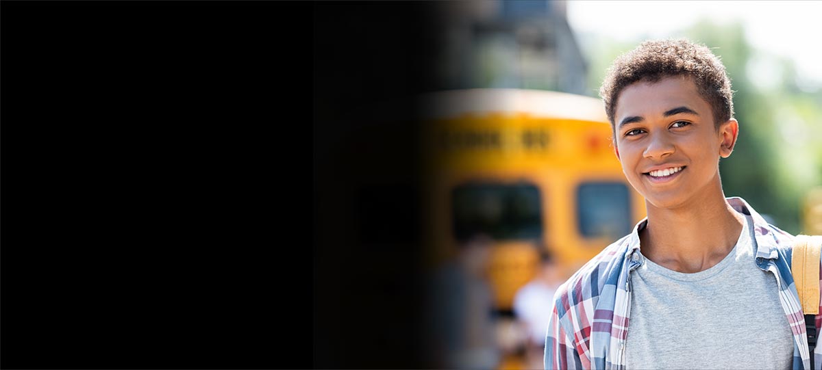 Child in front of a school bus.