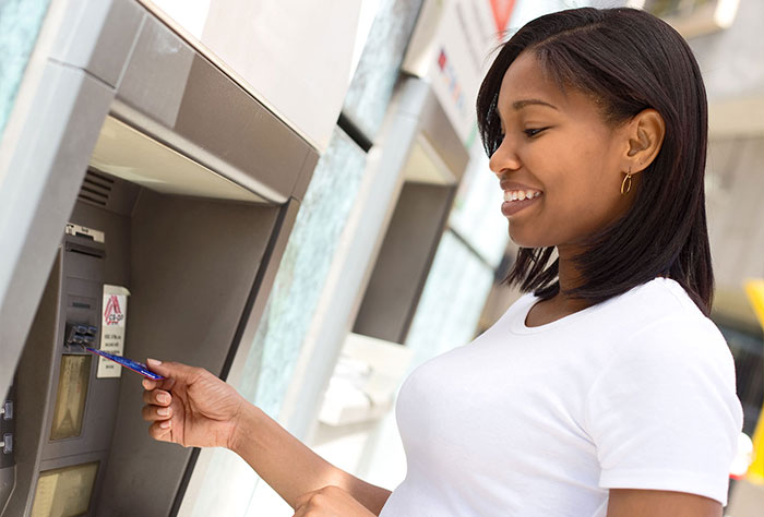 A woman uses her bank card on an ATM.