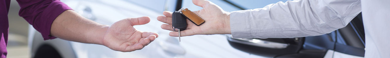 A man passes a set of car keys to another man.